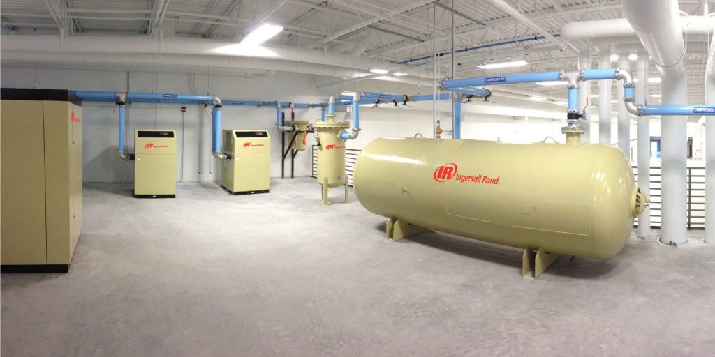 An industrial facility featuring multiple Arle Compressors of Florida and a large horizontal air receiver tank.